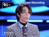 a man in a suit and tie is being interviewed by jeff hu yetao