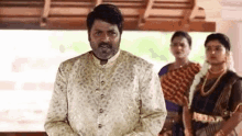 a man in a leopard print shirt is standing in front of a group of people .
