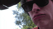 a close up of a man wearing sunglasses making a funny face
