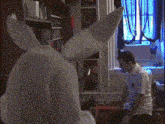 a man in a white shirt is standing in front of a stuffed bunny