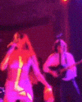 a woman is singing into a microphone while dancing on a stage