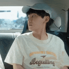 a young man wearing a white t-shirt that says beguiling