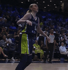 a female basketball player wearing a dallas jersey is running on the court