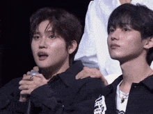 two young men sitting next to each other with one wearing a shirt that says " i love you " on it