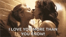 two women are kissing each other in front of a brick wall and the words `` i love you more than you know '' .