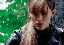 a close up of a woman wearing a leather jacket