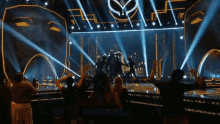 a group of people are dancing on a stage in front of a crowd .