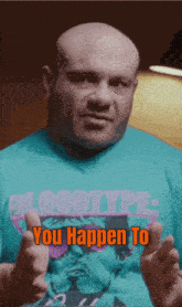 a bald man wearing a blue shirt that says bloodtype : you happen to