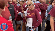 a woman holding a sign that says go sports in a crowd of people