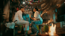 a man and a woman are sitting on a bench with the letters ji on the bottom right