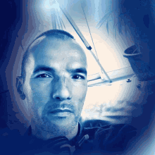 a man with a shaved head looks at the camera