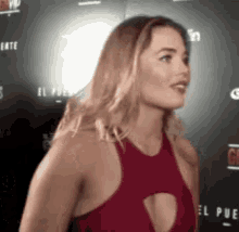 a woman in a red dress is standing in front of a sign that says el pue .