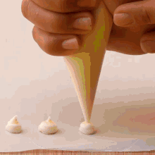 a person is using a piping bag to spread frosting on a table