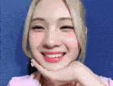 a woman with blonde hair and pink lipstick is smiling