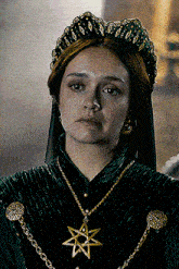a woman wearing a green dress and a necklace with a star pendant