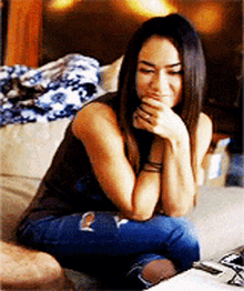 a woman sitting on a couch with her hand on her face