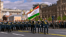 a group of soldiers marching down a street with a flag that says tajikistan on it