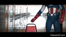 a man in a captain america costume is standing in a hallway holding a chair