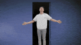 a man with his arms outstretched is standing in front of a door