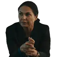 a woman in a suit is sitting with her hands folded in front of her