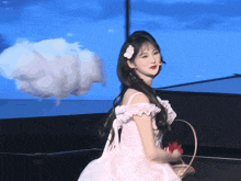 a girl in a white dress with a flower in her hair is holding a basket