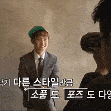 a man in a suit is being photographed by another man in a green hat