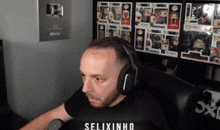 a man wearing headphones is sitting in front of a shelf full of funko pop figures