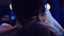 a close up of a person hugging another person with their eyes closed .