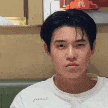 a young man wearing a white shirt that says primali