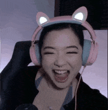 a woman wearing pink headphones with cat ears on her head