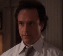 a man in a white shirt and tie looks serious
