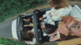 a group of people are riding in a car on a country road