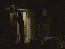 a man in a suit is standing in a room with boxes and a clock on the wall