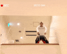 a man is standing on a balcony with the words seito cam on the screen