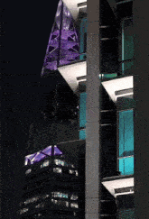 a tall building with a purple roof and a green roof