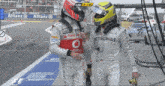 a man in a petronas racing suit talks to another man