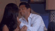 a man in a white shirt is being kissed by a woman .