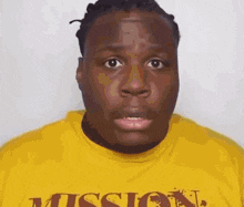 a man is wearing a yellow shirt with the word mission on it .