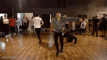 a group of people are dancing in a dance studio and the word dangson is on the bottom right