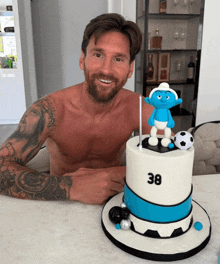 a shirtless man is sitting in front of a cake that says 38 on it