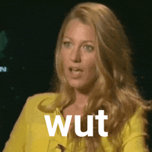 a woman in a yellow jacket with the word wut on her face