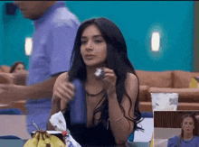 a woman is sitting at a table with a banana and a cup