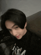 a young man is wearing a black shirt that says i am a on it