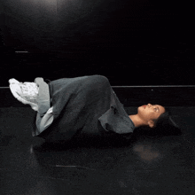 a person laying on their back with their legs crossed and a shirt that says asics on it