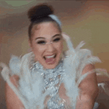 a woman in a white feathered dress is laughing .