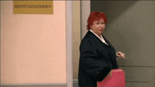 a woman with red hair and glasses is walking in front of a sign that says beratungszimmer