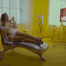 a woman in a white dress is sitting on a chaise lounge