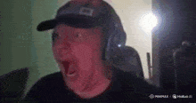 a man wearing a hat and headphones is making a surprised face