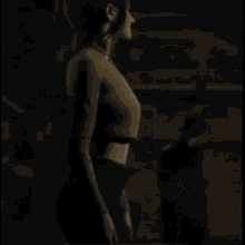 a woman in a green crop top and black pants is standing in a dark room