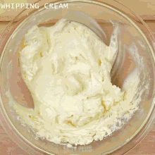 a person is pouring milk into a glass bowl of butter